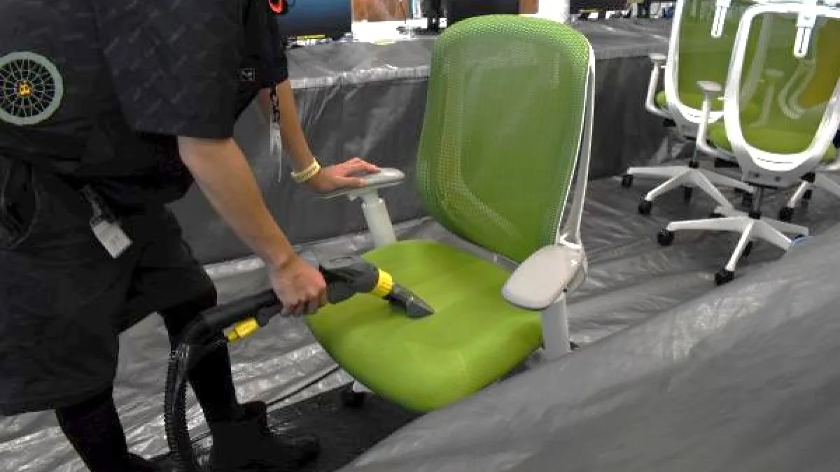 オフィスチェアの座面を専用機材で洗剤洗浄している様子